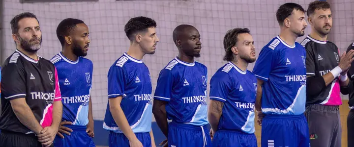 Jogadores de futsal alinhados com equipamentos patrocinados pela ThinkOpen Solutions, representando espírito de equipa e estratégia.