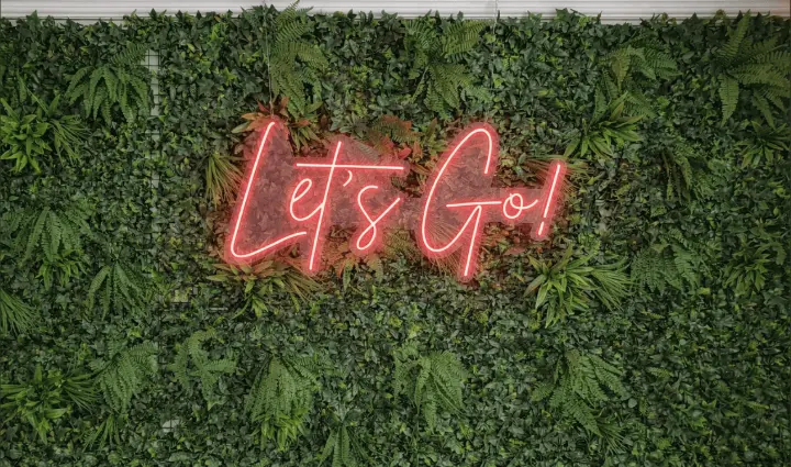 Espaço de bem-estar no escritório da ThinkOpen Solutions Jardim com néon Let's Go no escritório da ThinkOpen Solutions